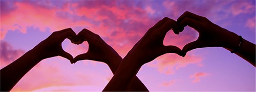 Hands come together each shaping a heart 