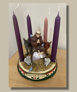 Image shows St. Francis in Nativity scene surrounded by Advent Candles.