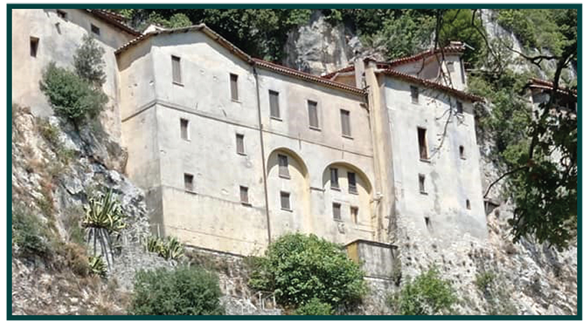 The hermitage of Greccio stands out prominently on the side of a cliff.